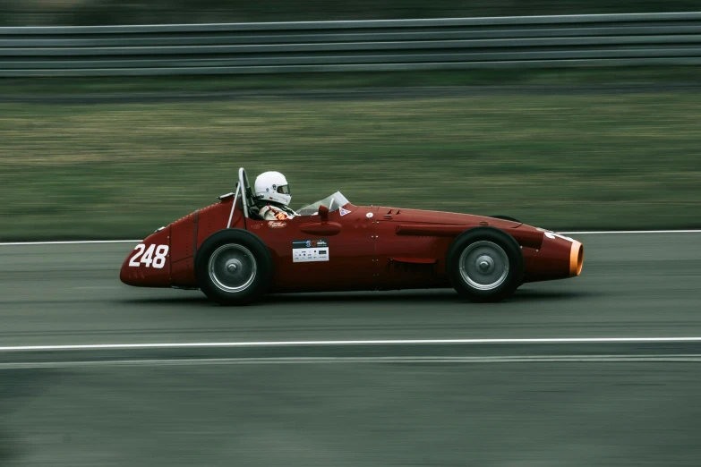 a red race car going down a road