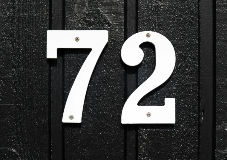 a metal address or number displayed on the front of a wooden door