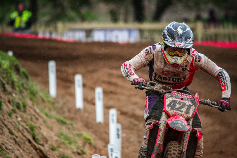 a man riding on the back of a dirt bike on a race track