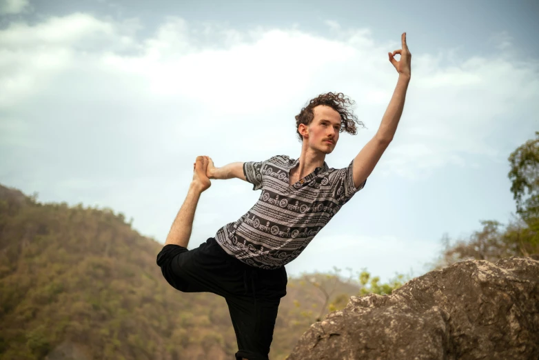 a man doing an acrobatic move on a hill