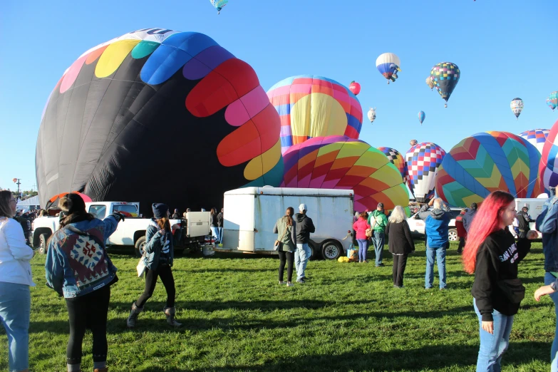 a group of people looking at  air balloons