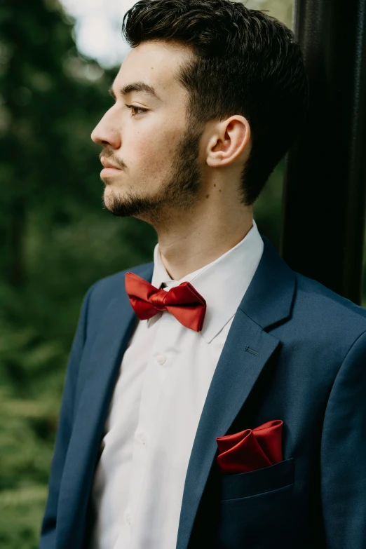 a man is wearing a suit and a red bow tie