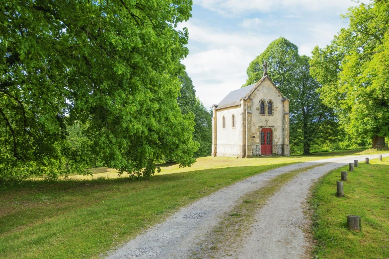 an old, crumbling church stands on the side of a dirt road