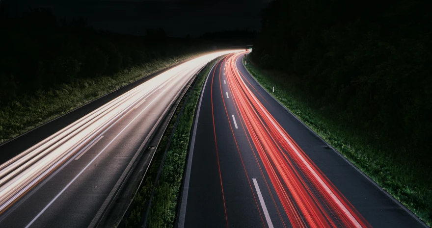 a night scene with car lights and the colors red and white