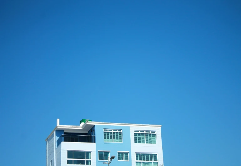 the building has three stories and blue paint