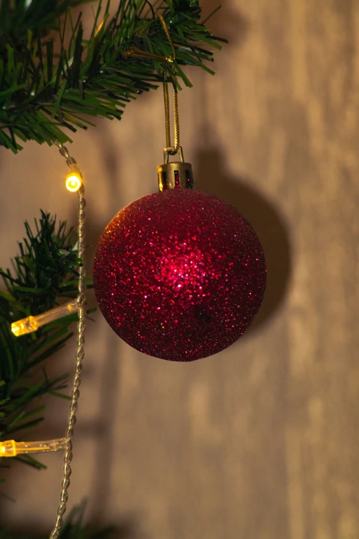 a christmas ornament on top of a fir tree