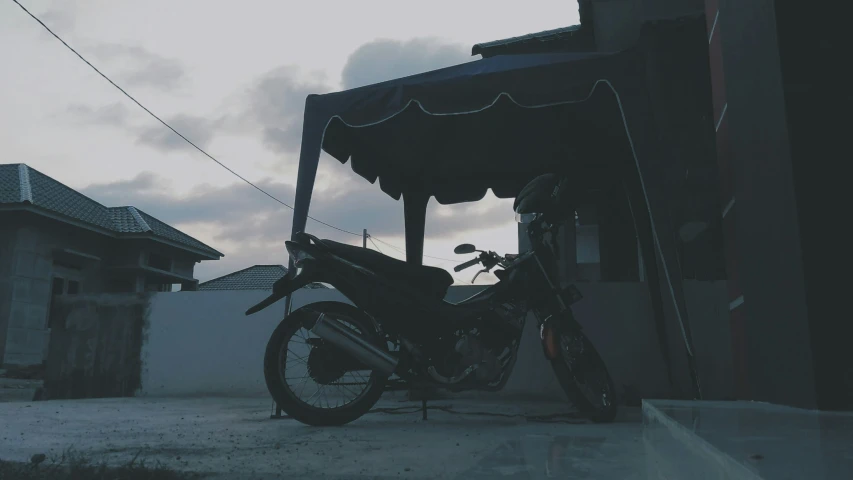 a motor bike is parked near the outside of a home