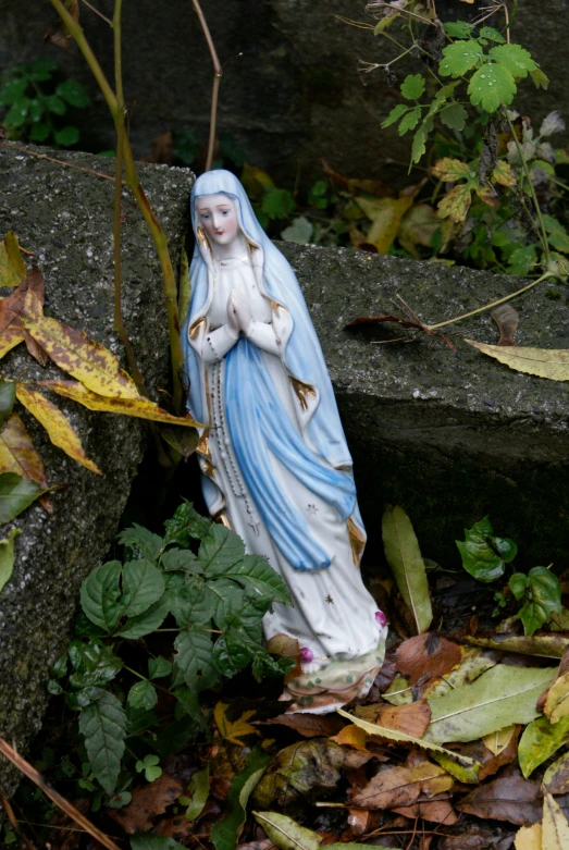 a statue of the mary lounging on top of rocks