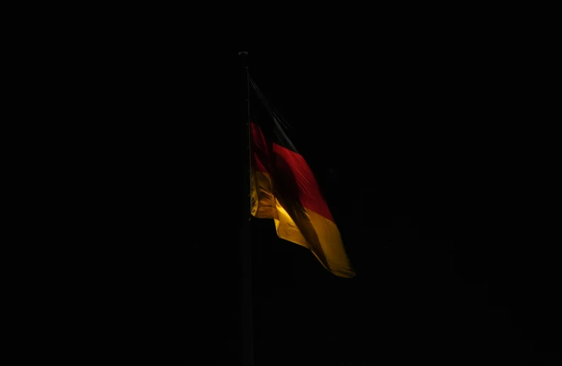 the german flag blowing in the dark with stars in the sky