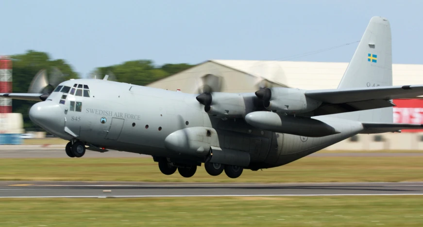 a large propeller plane taking off from an airport runway