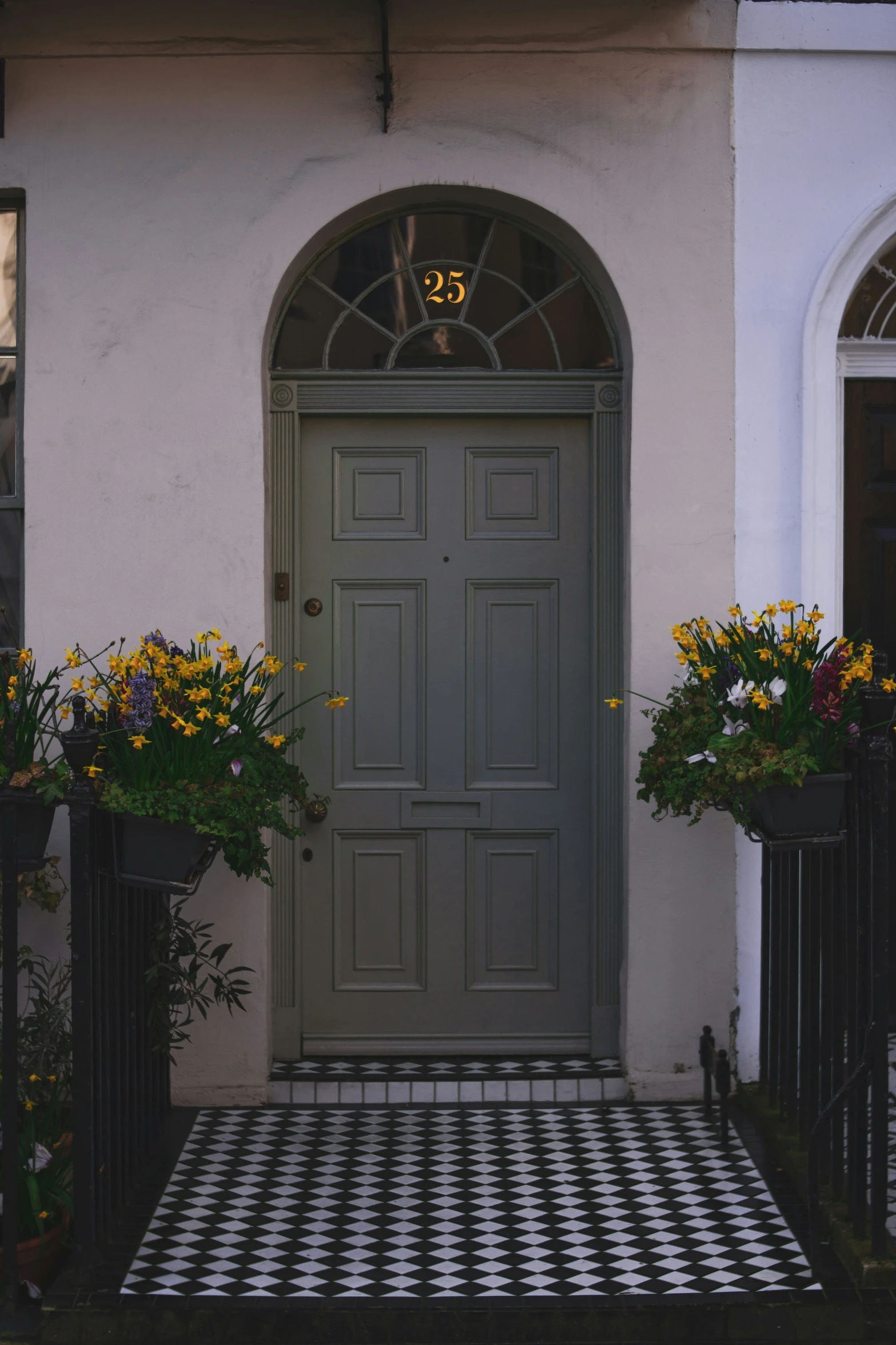 some flowers sitting in front of a doorway with a checkerboard floor