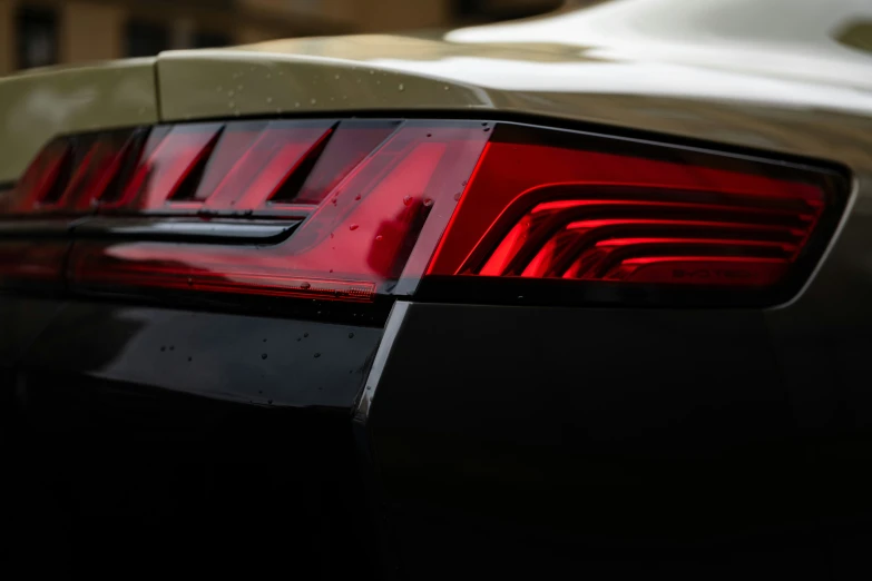 the tail light of a car with black and beige paint