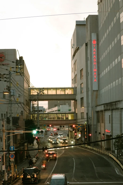 cars driving down a city street near tall buildings