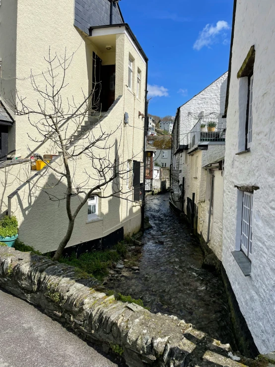 a river is running through a small alley way