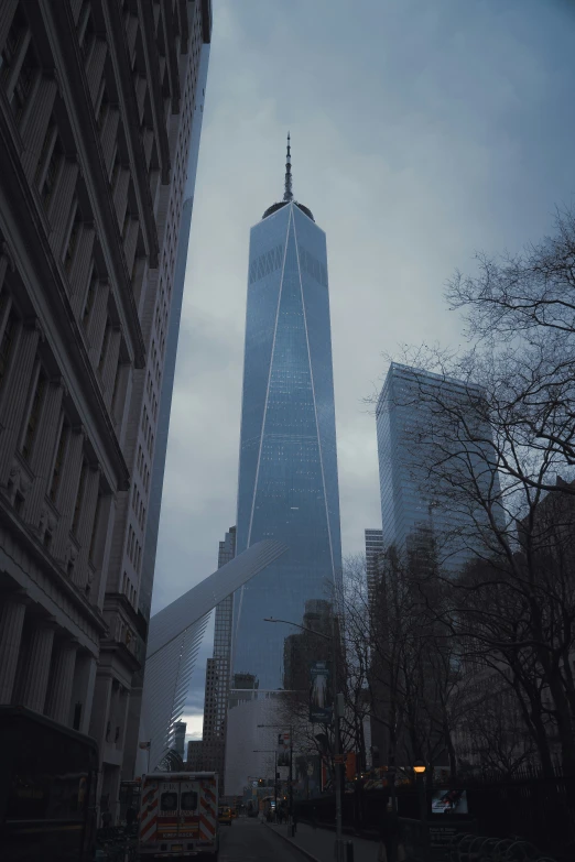 a tall skyscr towering over a street in the middle of a city