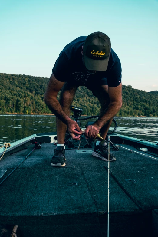 the man is holding his shoe while standing on the edge of a boat