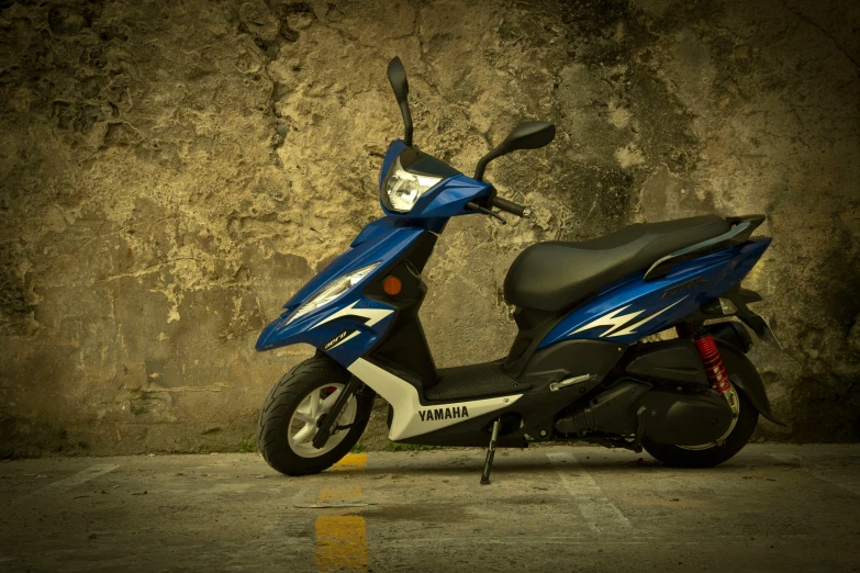 a motor scooter is parked in front of a concrete wall