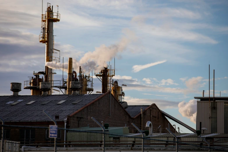 smoke billows from a building with several industrial structures