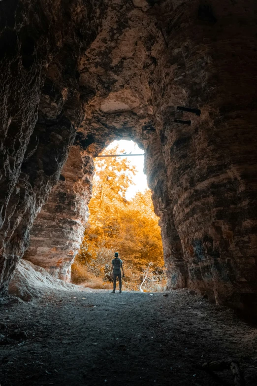 a lone man is standing in front of a tunnel