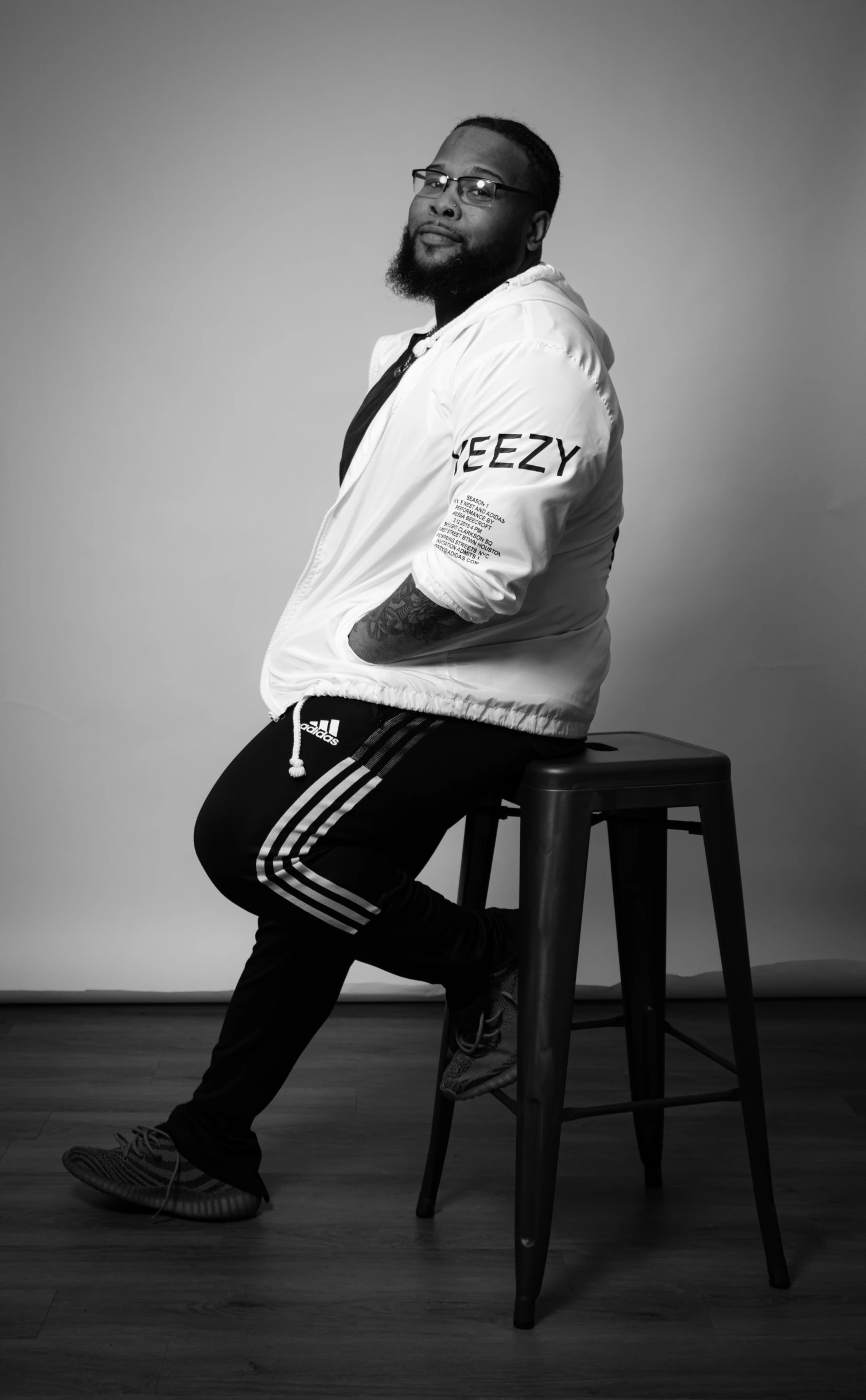 a man wearing a jersey sits on a stool