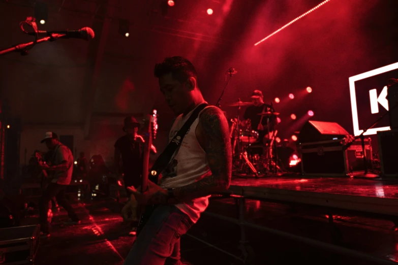 a man holding onto his guitar on stage