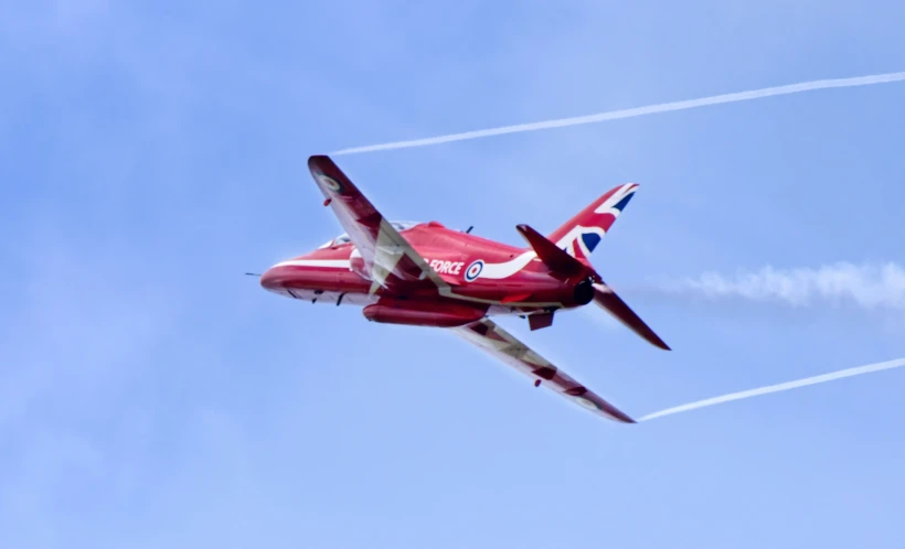 a red and white fighter jet flying through the sky