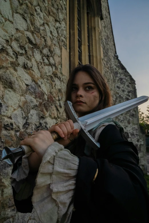 a girl is standing outside with a giant sword