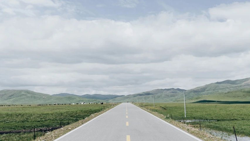 an empty highway with mountains in the background