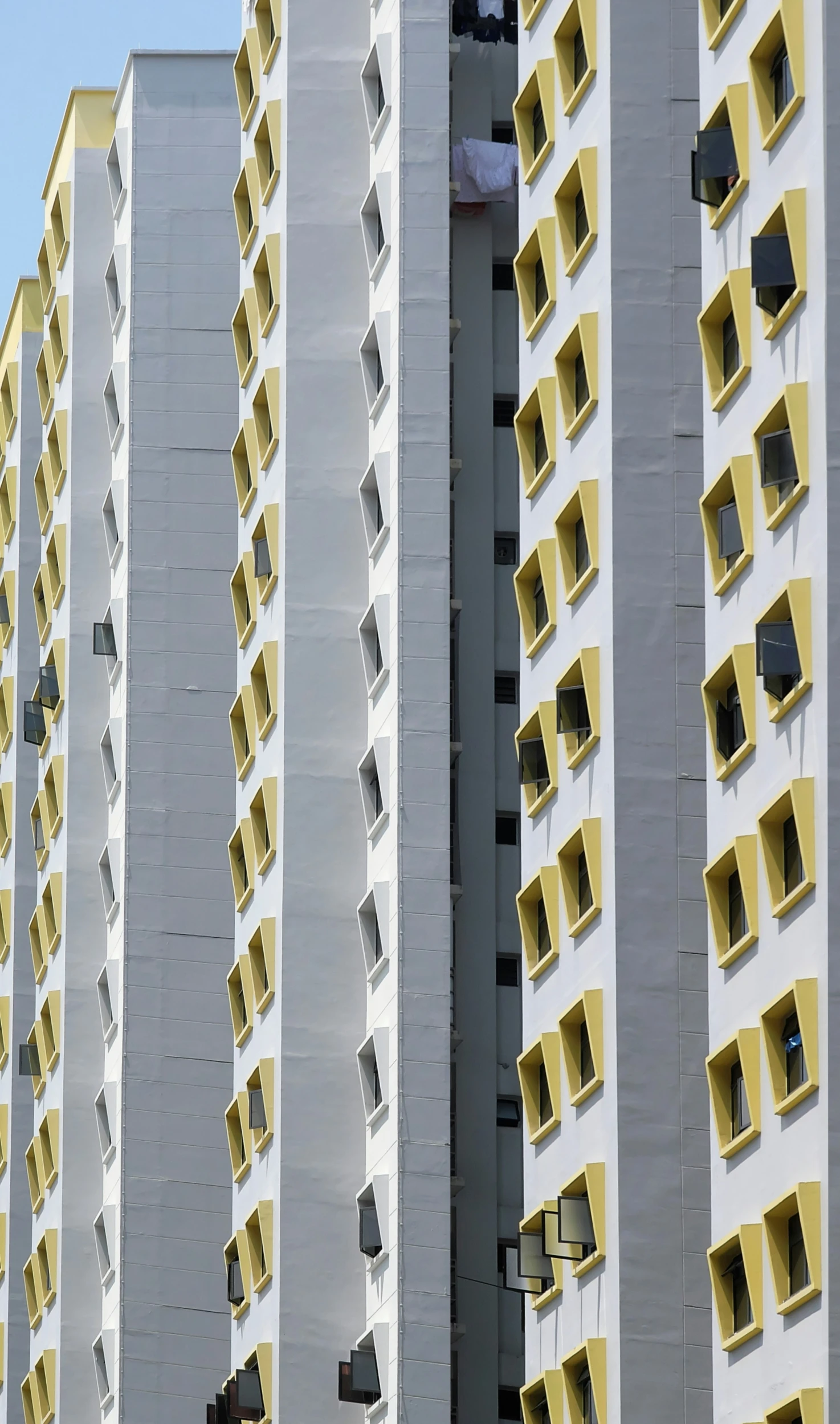 there is a tall apartment building with yellow and white windows