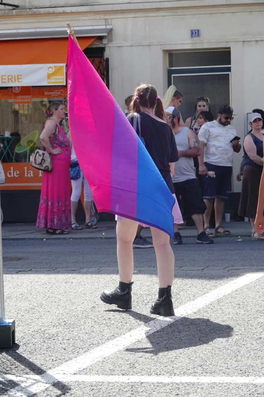 the woman is holding a rainbow colored flag