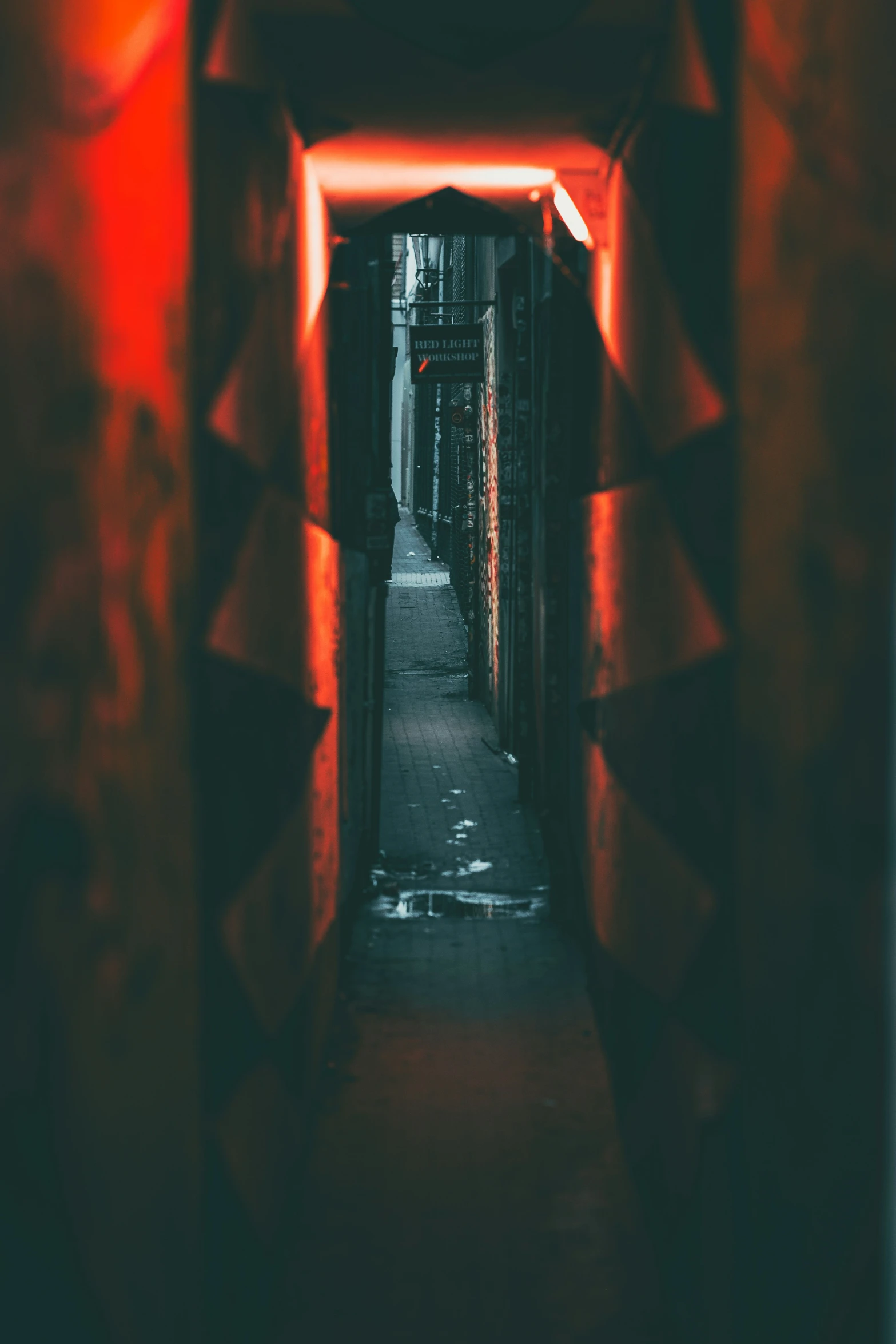 a hallway with a light and red lights on the walls