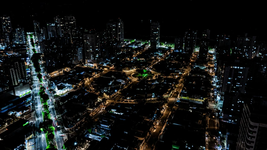 city street and skyscrs with lights from above at night