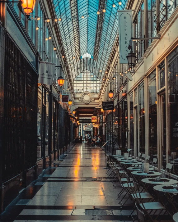 a glass covered building with tables and chairs