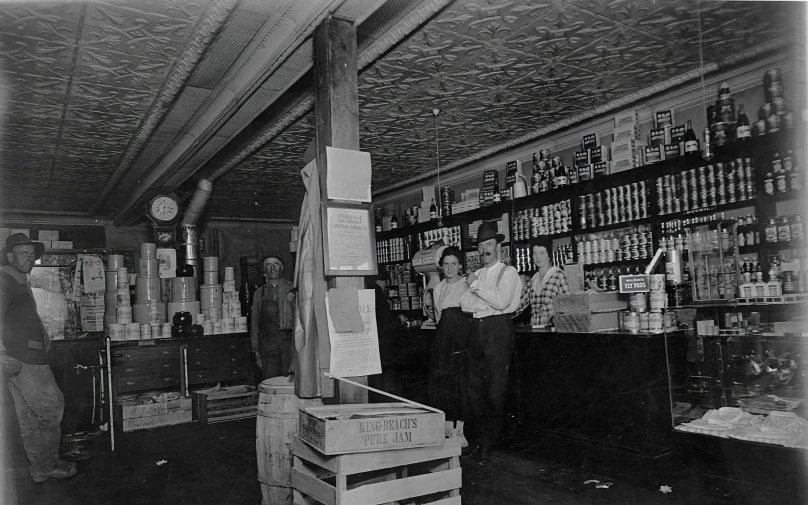black and white pograph of two men working in a large soda shop
