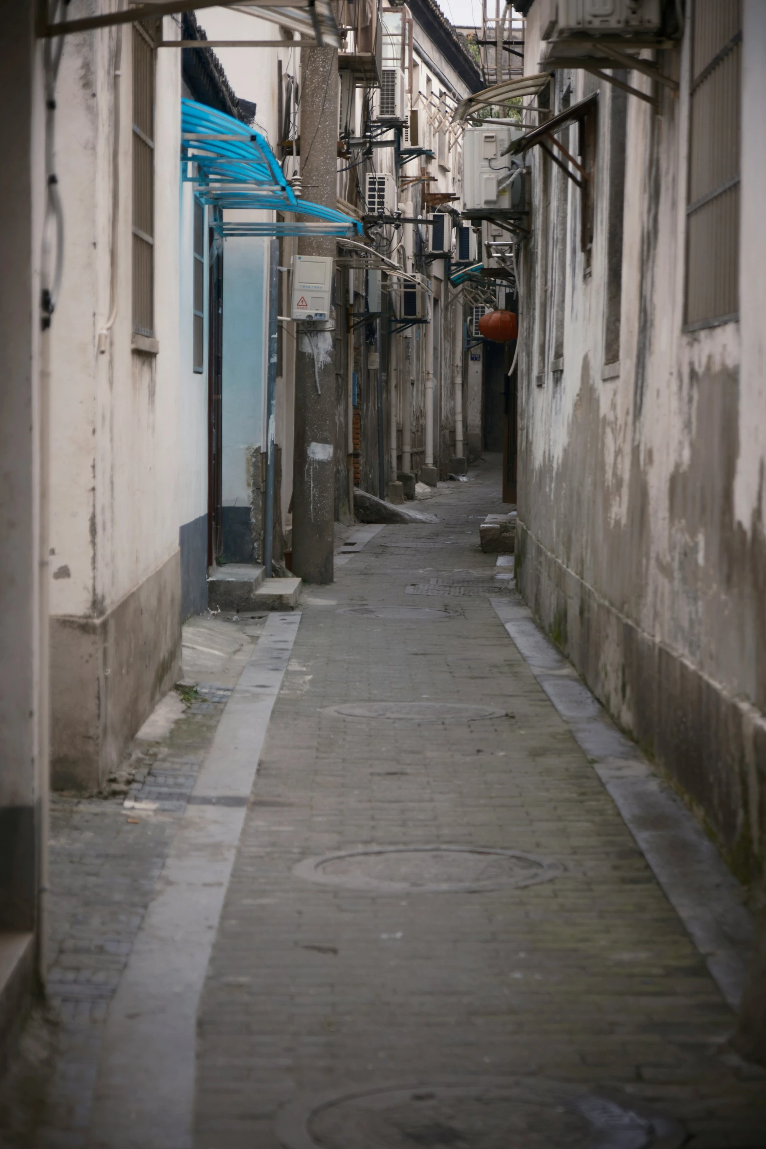 a narrow alley way with a building and a few windows