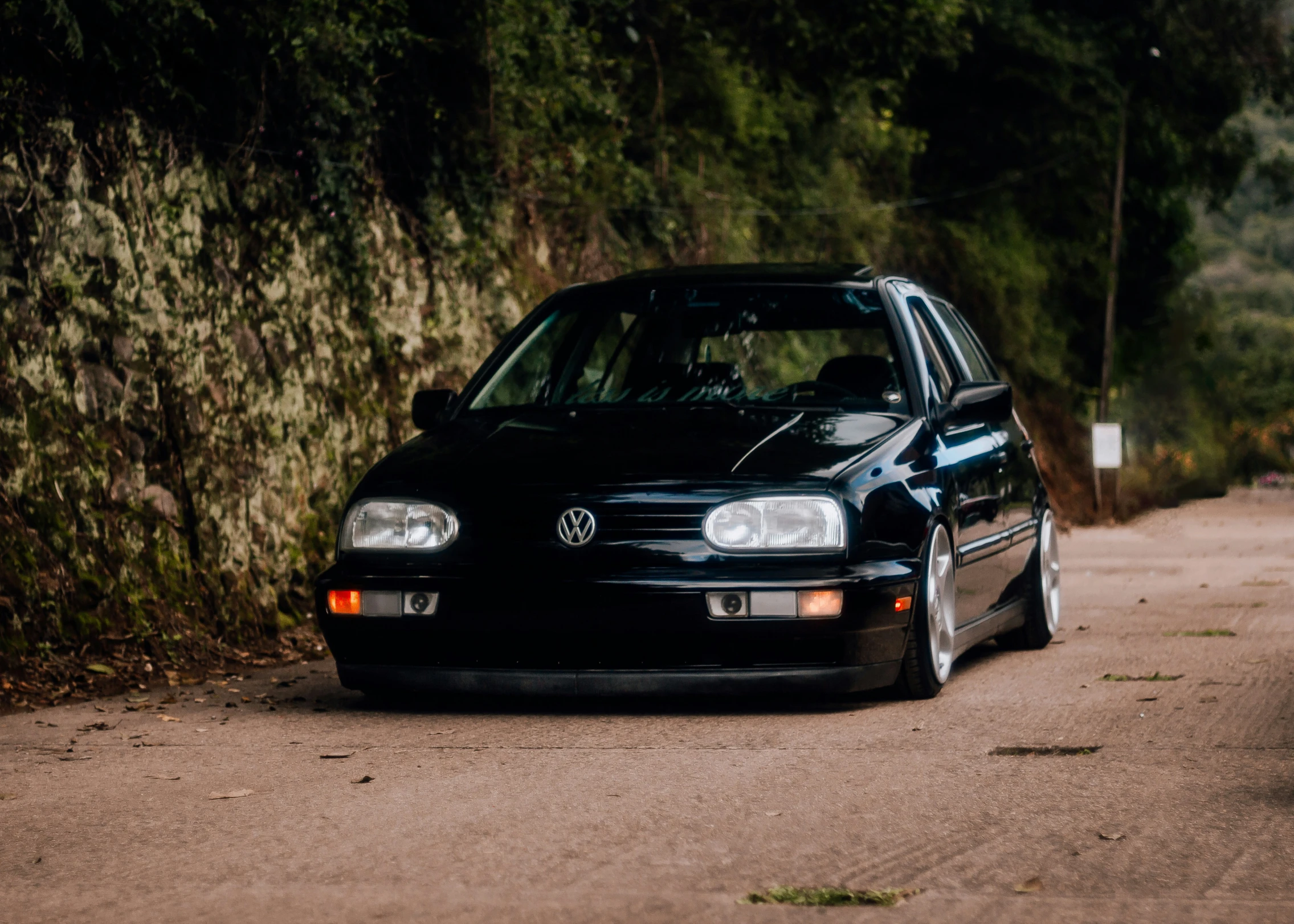 an old volkswagen car parked on the side of a road