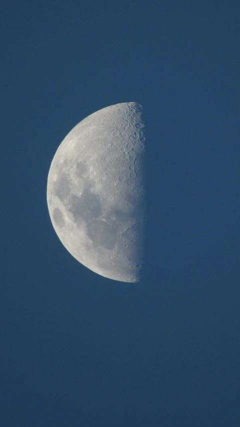 a moon against a blue sky is seen here