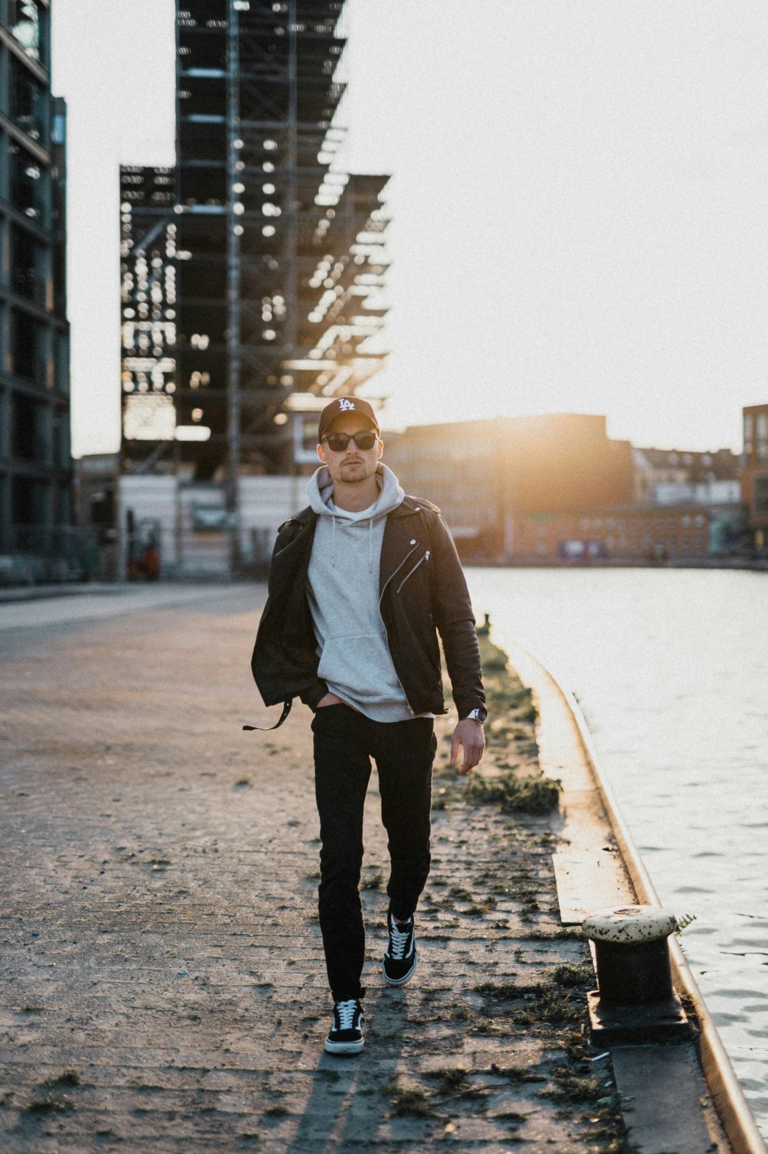 the man is walking on the sidewalk by the water