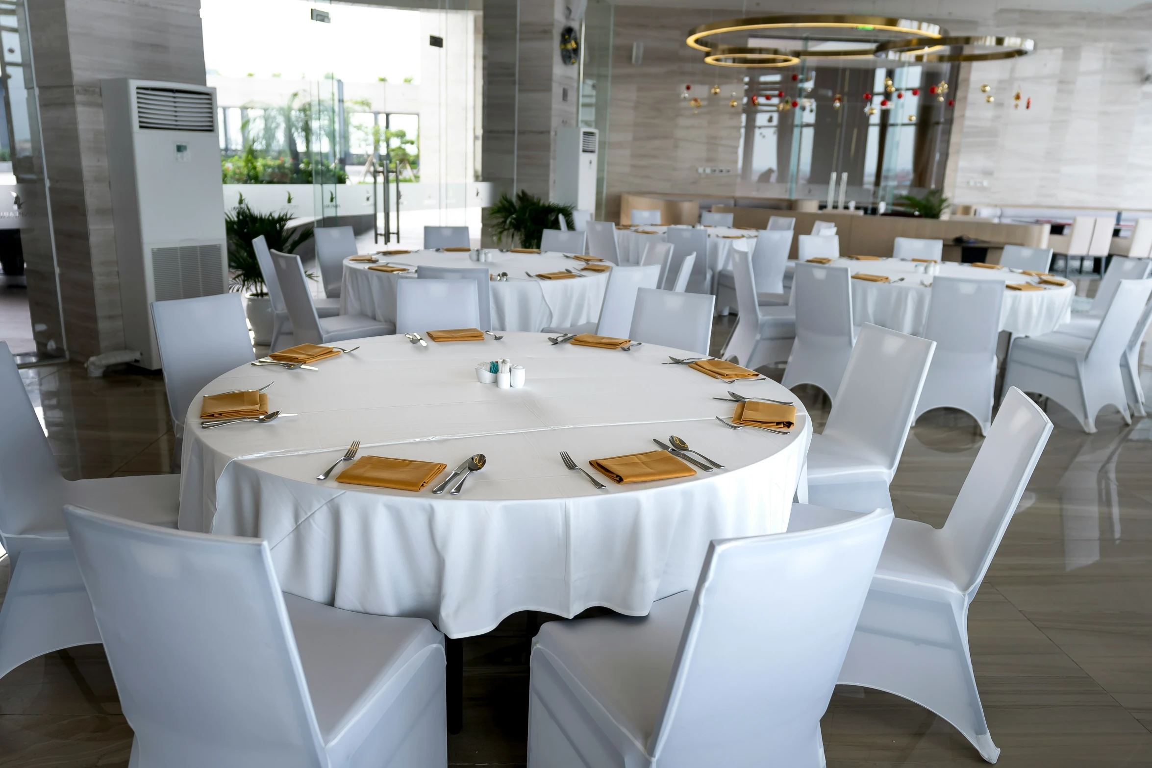 the round table has yellow napkins and silverware on it