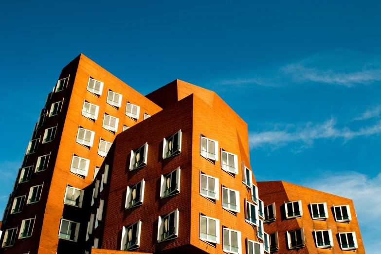 a tall red building with multiple windows on a sunny day