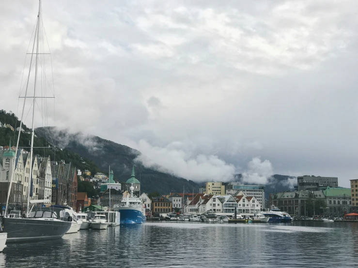 there are many sailboats out in the water near a city