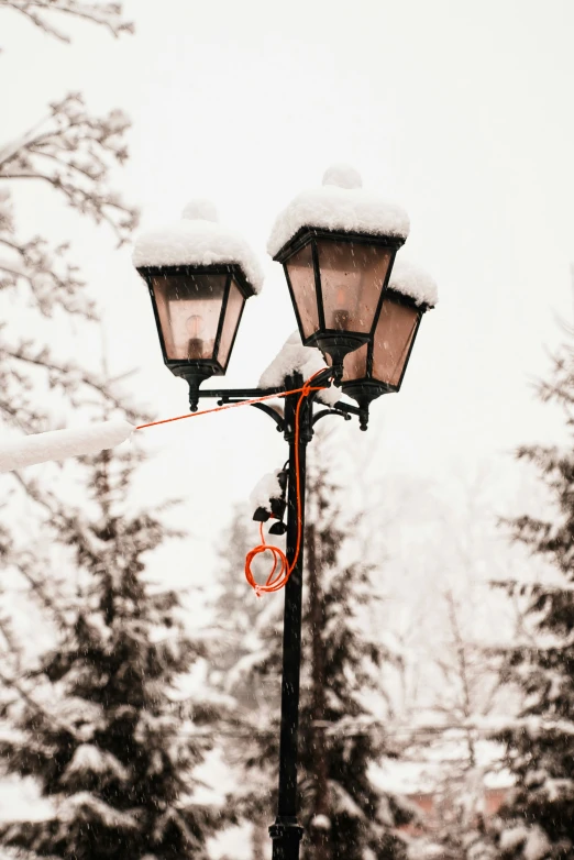 three street lights on top of a pole covered in snow