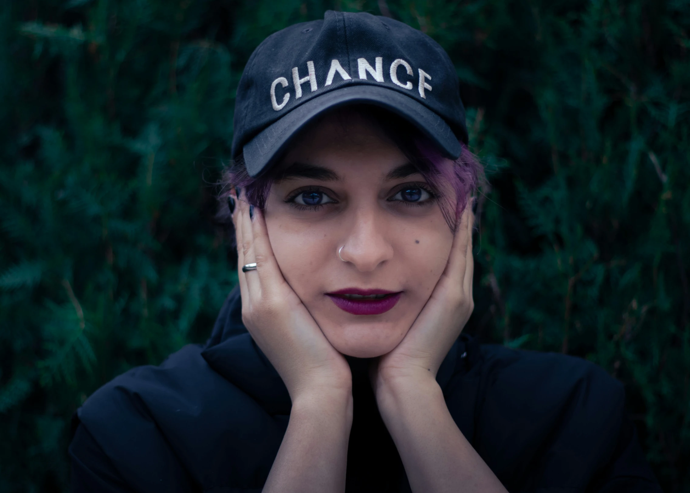 a woman is posing with her hands over her face