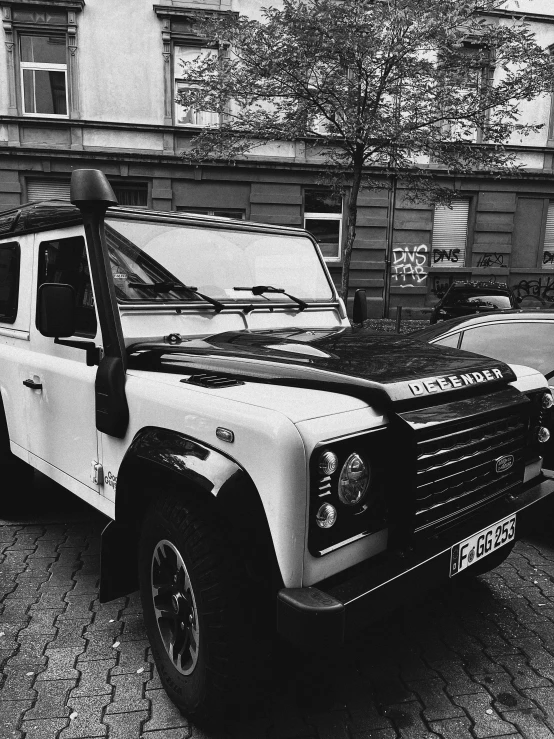 a car parked in front of a building on a brick sidewalk