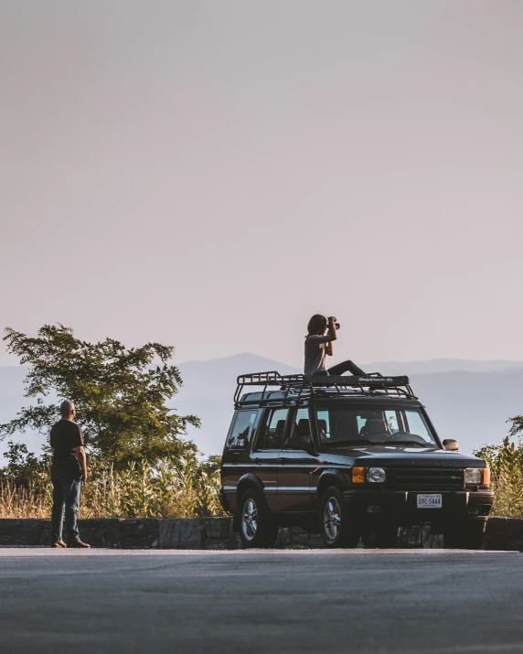 people standing on the road as the van sits in the road