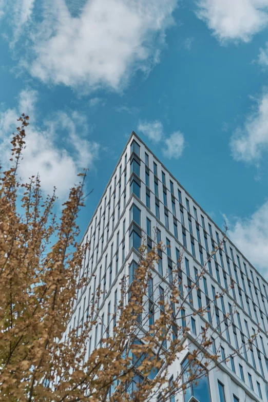 the tall building has a blue sky as it looks like it is falling down