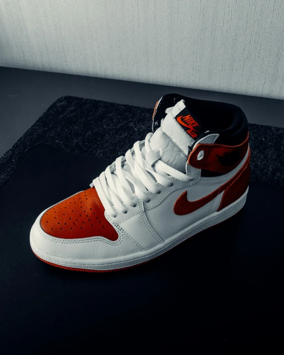 a pair of white and orange shoes sitting on top of a table