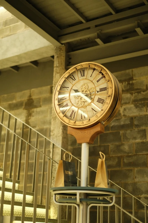 an old clock standing against a brick wall