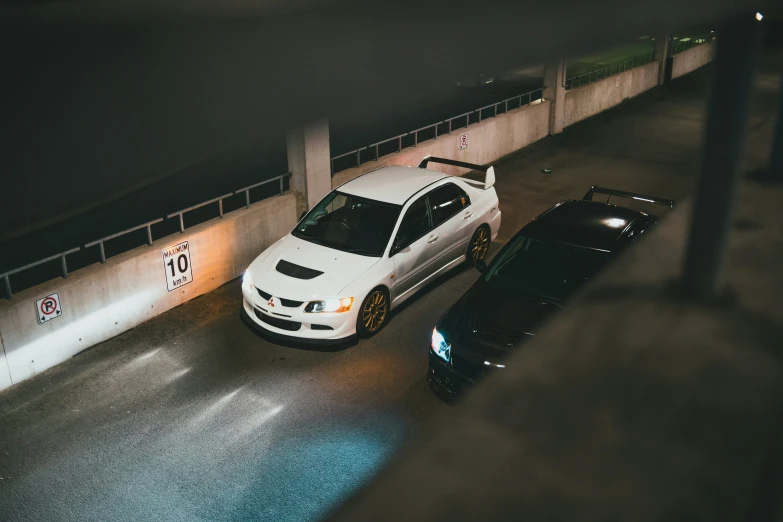 a white car parked beside another black car