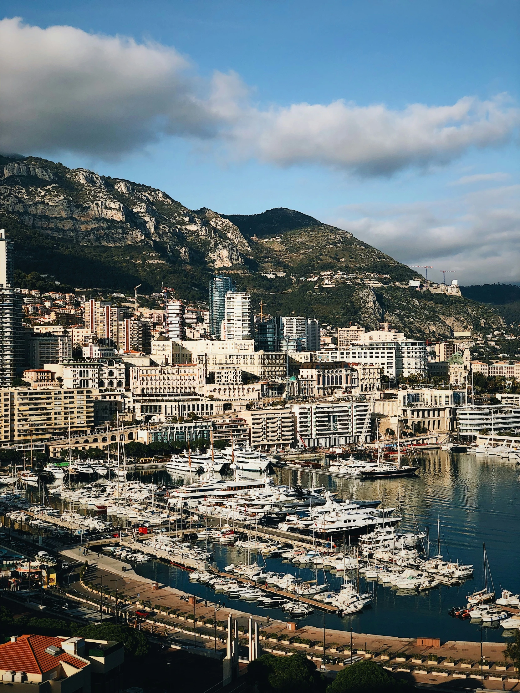 a city on a mountain in front of some boats